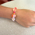 Colorful beaded bracelet on a wrist with a neutral background