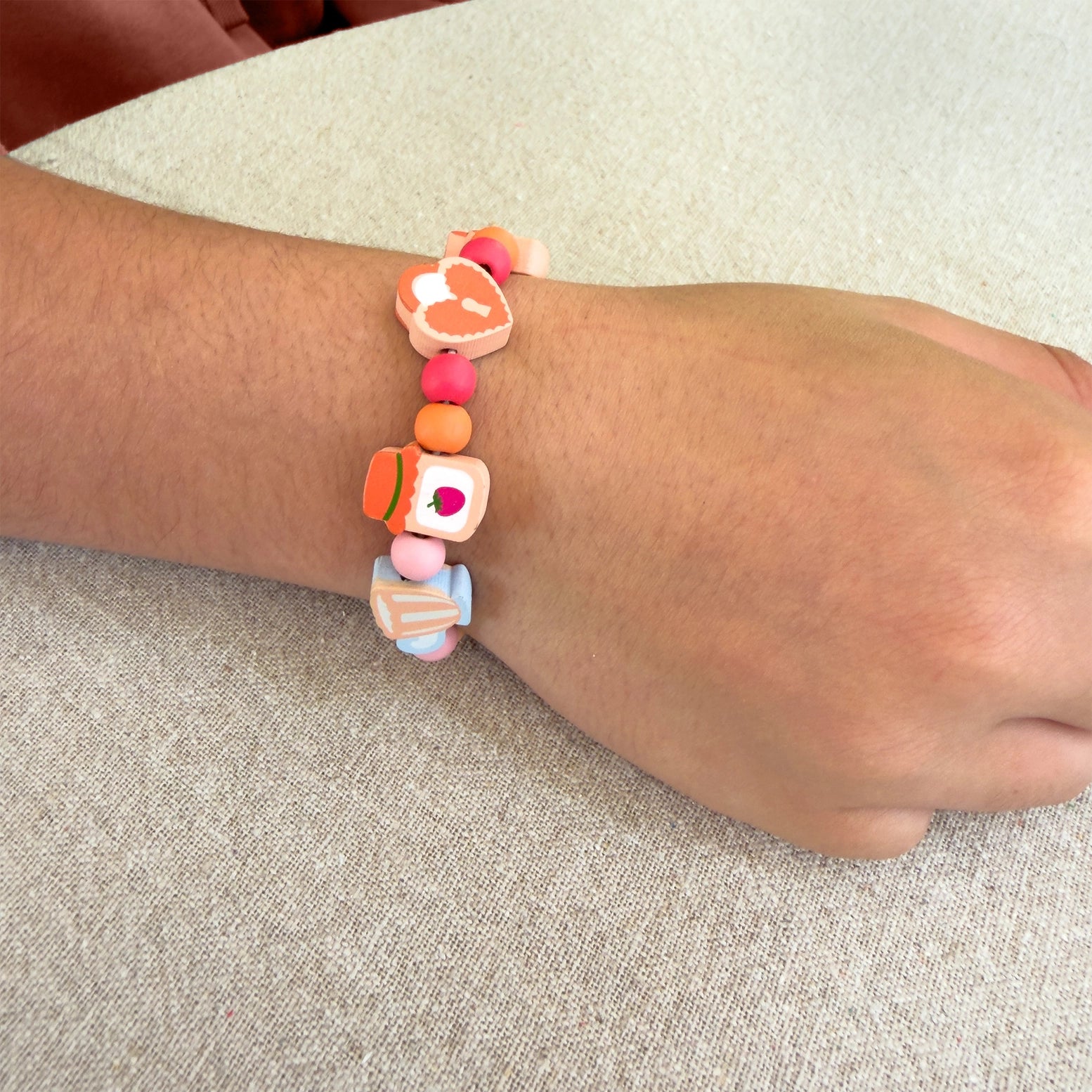 Colorful beaded bracelet on a wrist with a neutral background