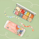 Colorful bead set with tools on a green background