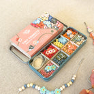 Bead kit with colorful beads and tools on a beige surface