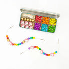 Colorful bead kit with a completed necklace on a white background