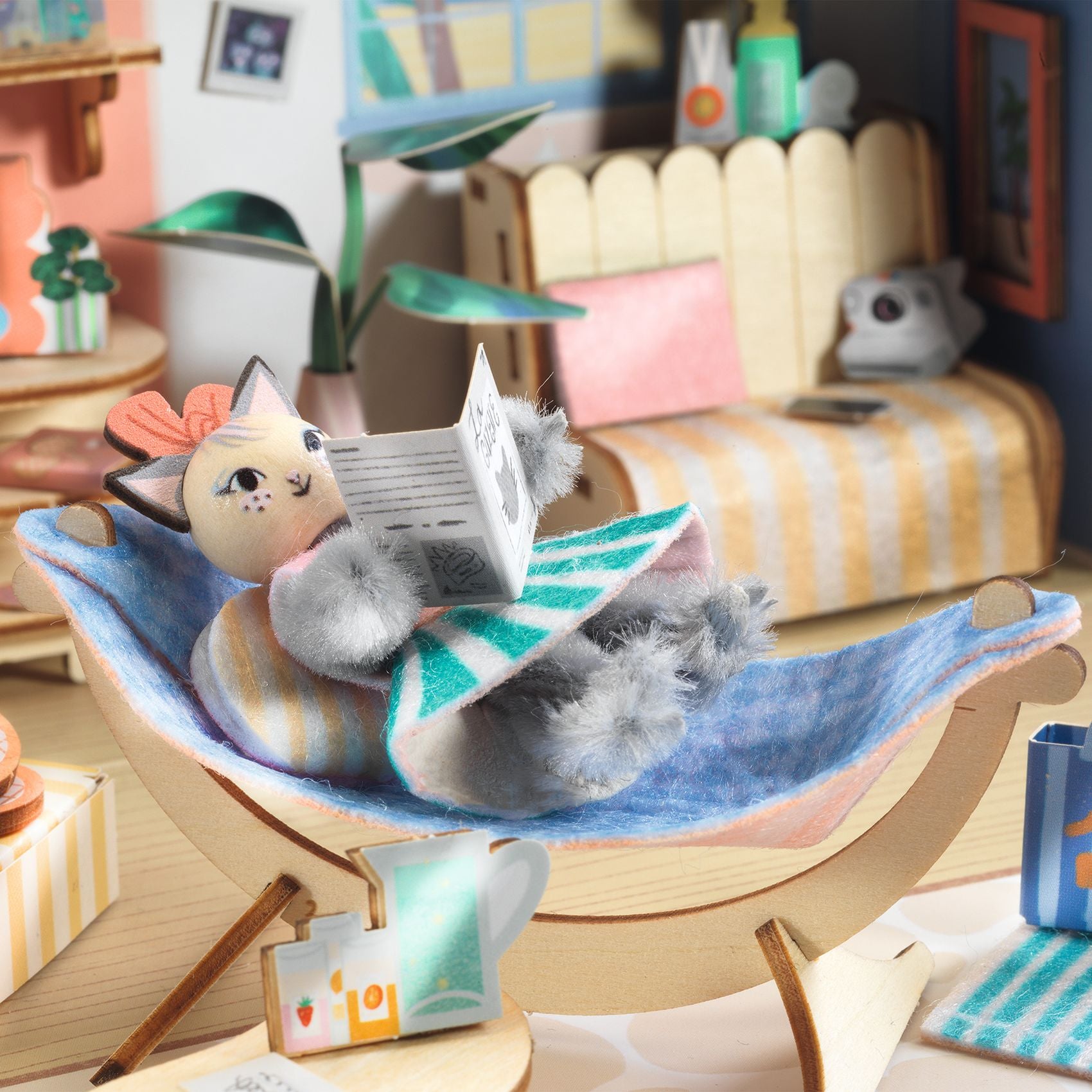 Cat-shaped toy reading a book in a hammock with a cozy room background