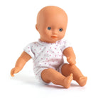Baby doll wearing a white outfit with pink polka dots on a white background