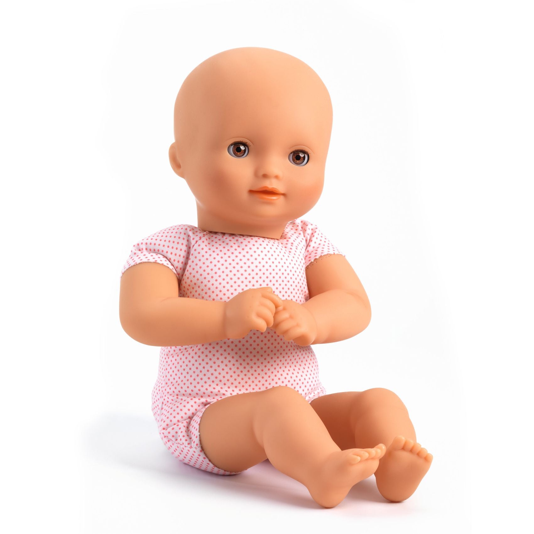 Baby doll wearing a pink polka dot outfit on a white background