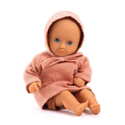 Doll wearing a pink hooded outfit on a white background