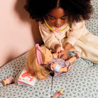 Child playing with a doll and medical toys on a patterned surface