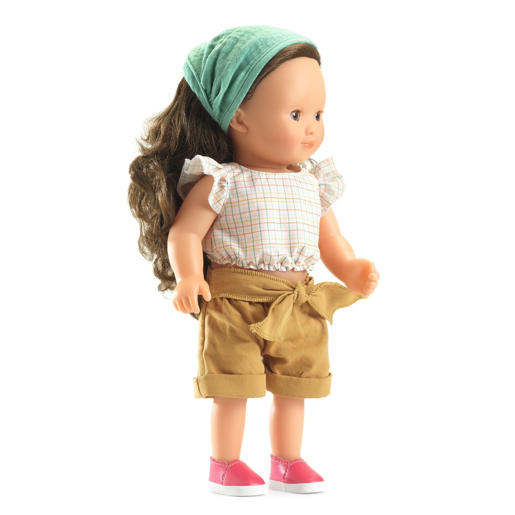 Doll wearing a green headband, white top with plaid pattern, beige shorts, and pink shoes on a white background