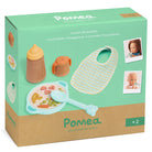 Pomea toy set packaging with a bib, bottle, and plate on a green and brown background.