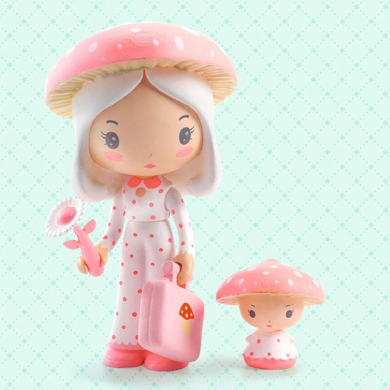 Two small figurines with mushroom hats on a light green background, featuring the brand 'tinyly'.