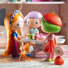 Toy figures of children and animals in a colorful room setting