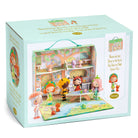 Toy dollhouse set in a box with characters around it, featuring a light blue background.