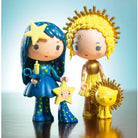 Two stylized figures, one in blue with a star and the other in gold with a lion, on a reflective surface with a gradient background.