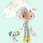 Two toy figures, one with a colorful umbrella and the other a small animal, on a light blue background with 'tinyly' branding.