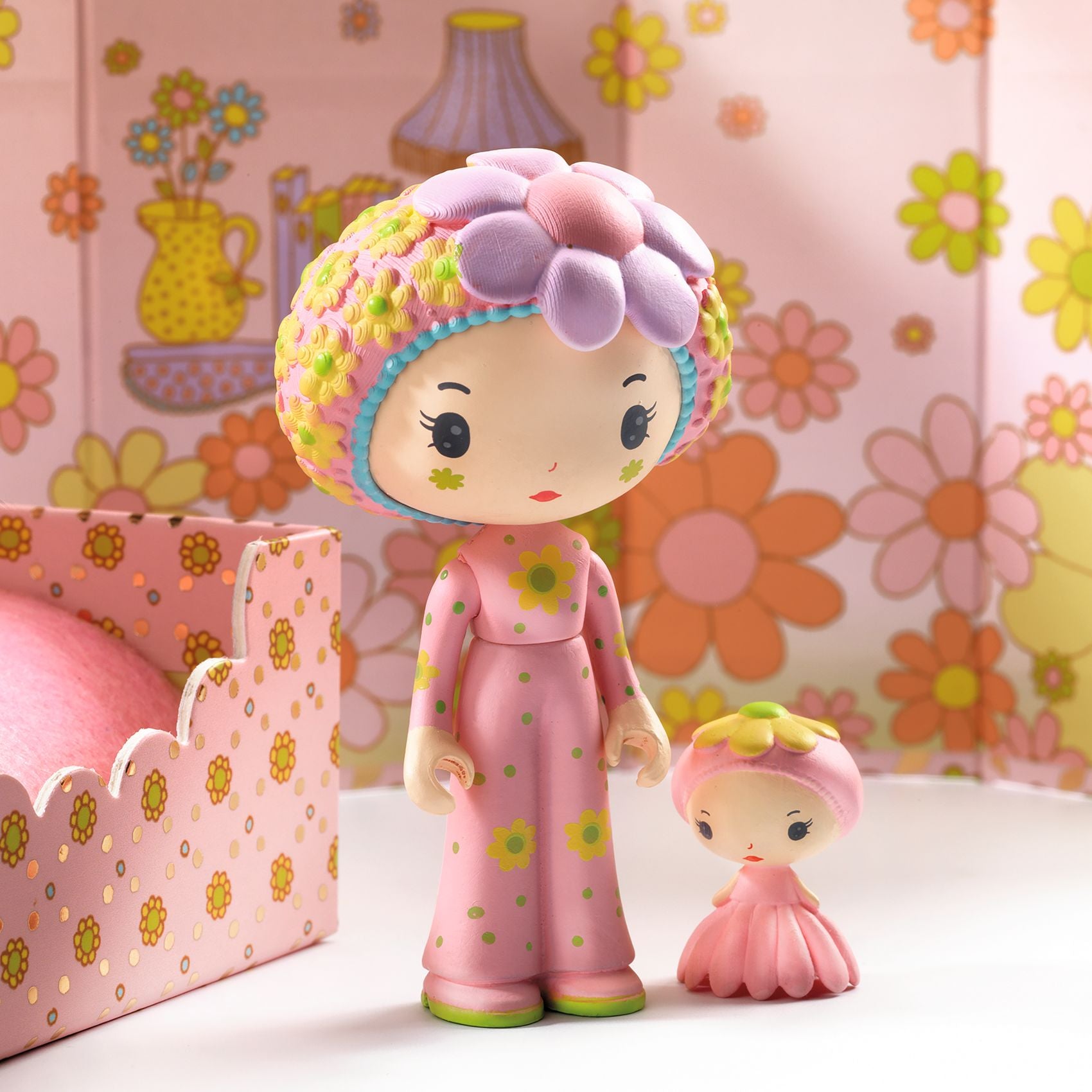Two colorful figures with floral designs against a floral-patterned background