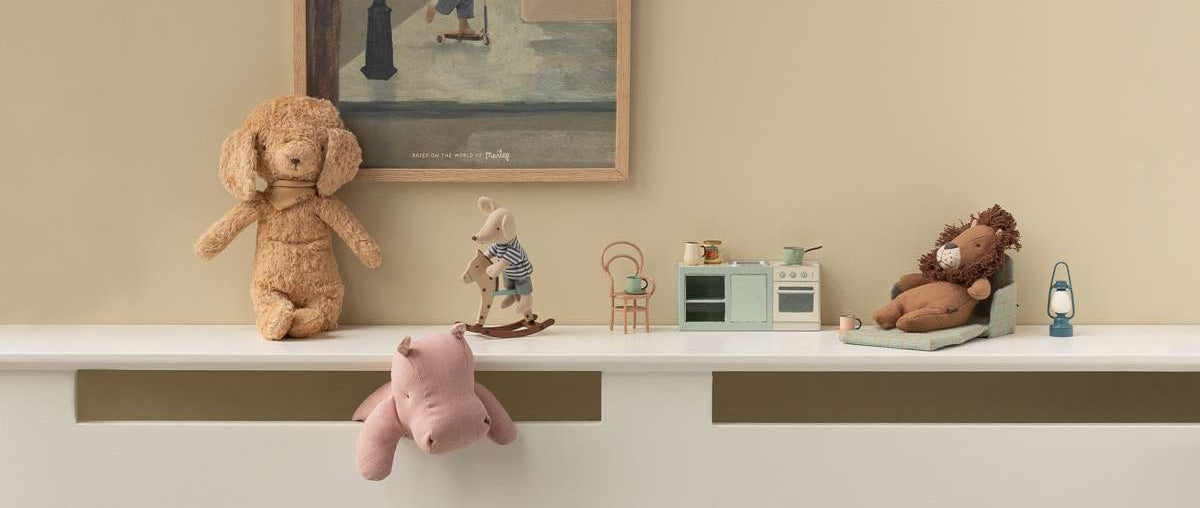 Children's room with Maileg toys on a shelf and a framed picture of a Maileg mouse on the wall.