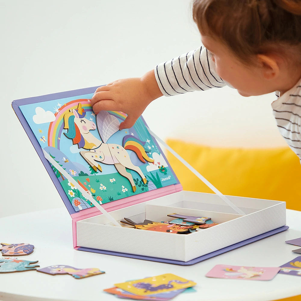 Child playing with a colorful puzzle book featuring a unicorn on a white surface.