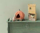 Pumpkin-shaped toy house with a small castle on a green surface
