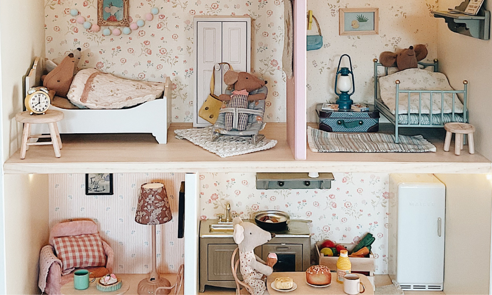 Miniature Maileg dollhouse with detailed furniture and decor, including a bedroom and kitchen.