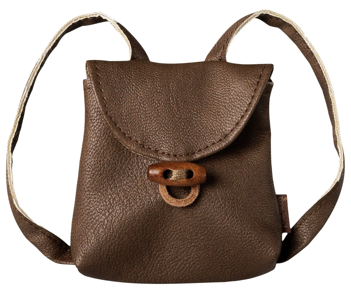 A small brown pebbled leather mini backpack with a flap closure and a wooden toggle clasp, shown against a plain white background.