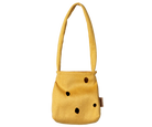 A small mustard yellow shoulder bag with a textured fabric finish, featuring black polka dots and a small brown brand tag on the side, set against a plain white background.