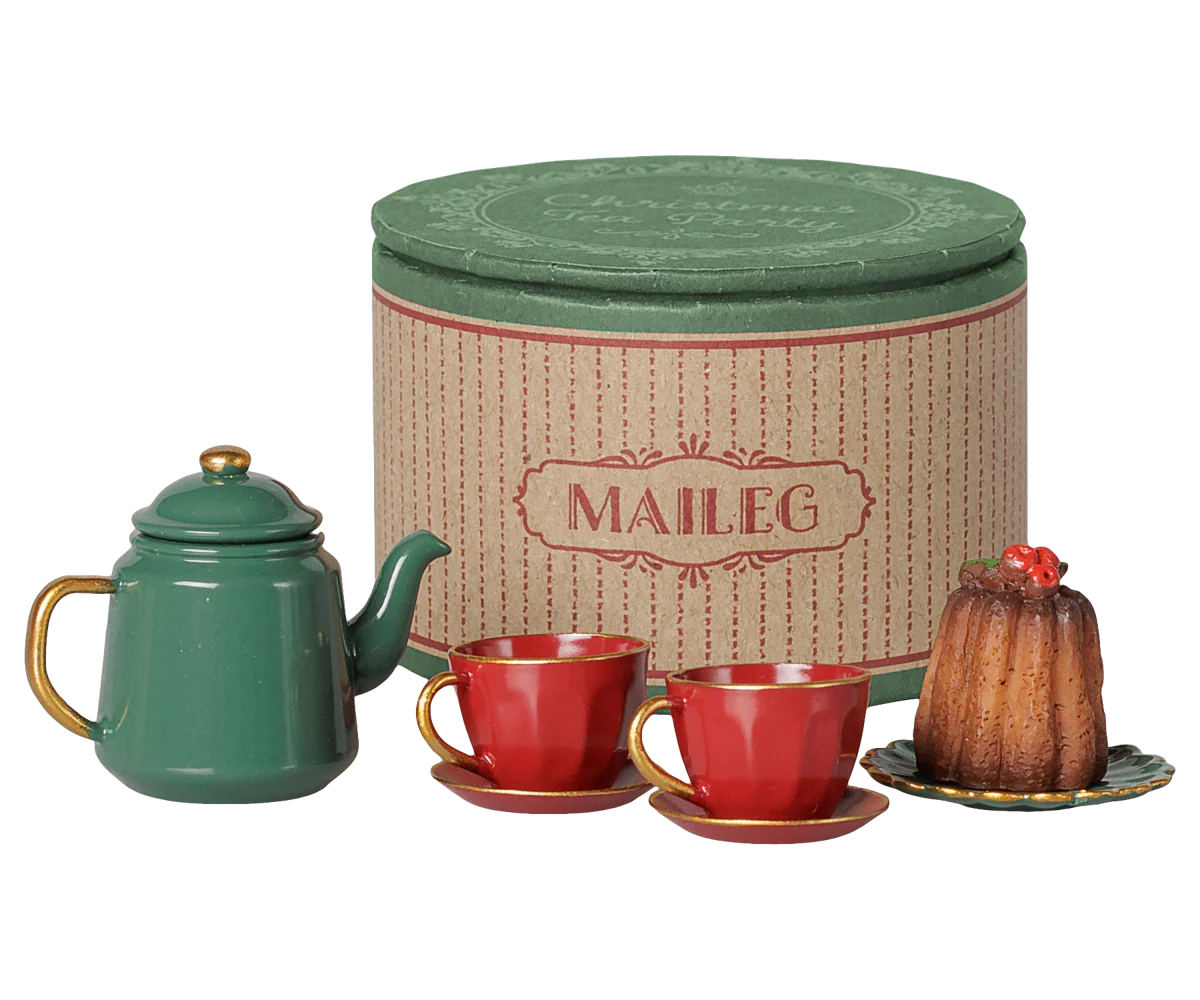 Maileg tea set with a green teapot, two red cups with gold handles, a small cake on a saucer, and a tall round cream-colored tin with a green lid, all on a white background.