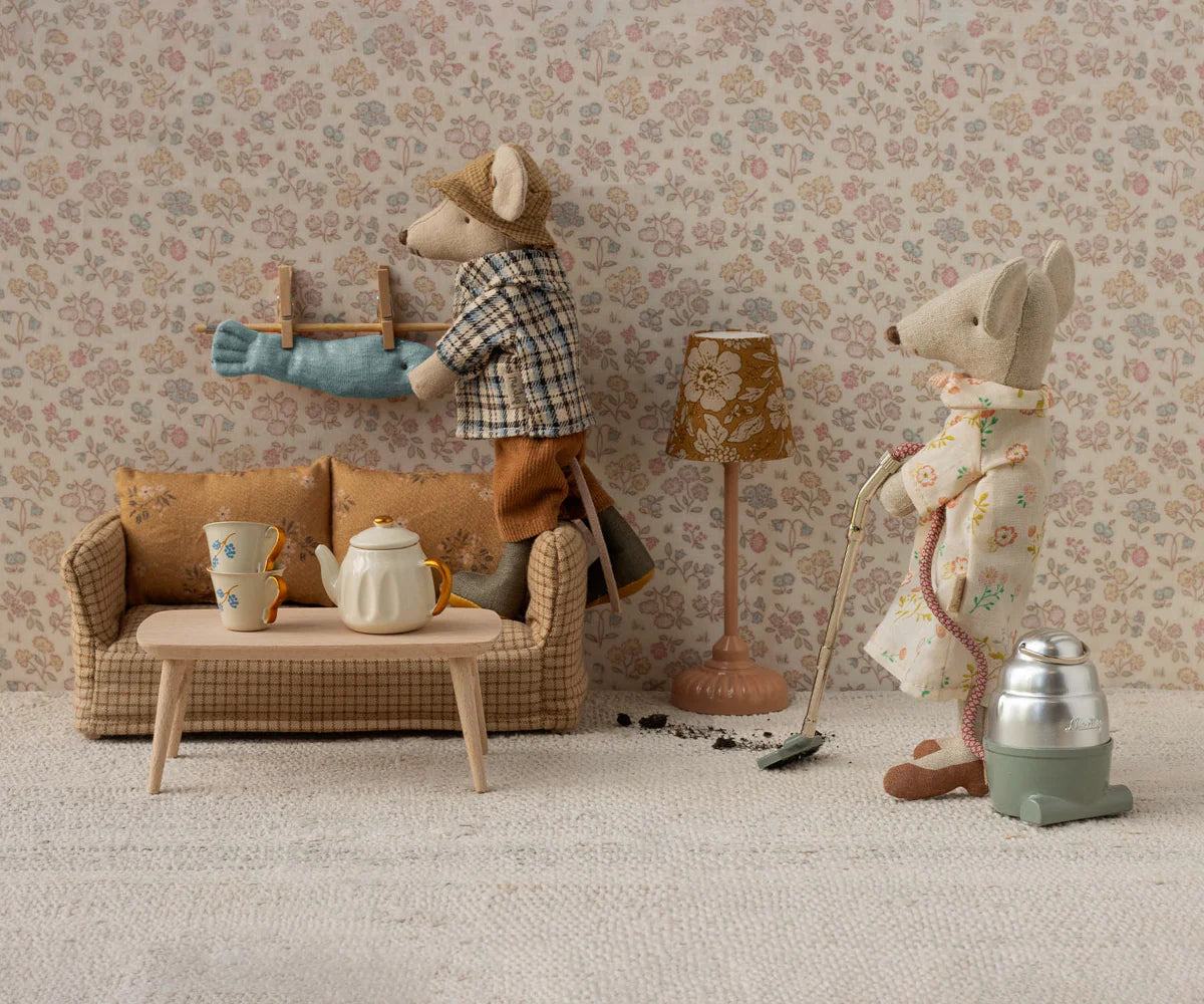 Two toy mice in a living room setting with furniture and decor.
