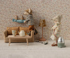 Two toy mice in a living room setting with furniture and decor.
