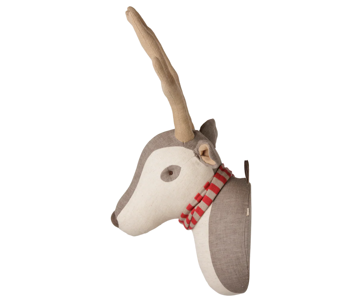 A decorative wall-mounted plush deer head with a light tan antler, cream face, taupe-gray neck and ear areas, and a red-and-white striped scarf, shown against a plain white background.