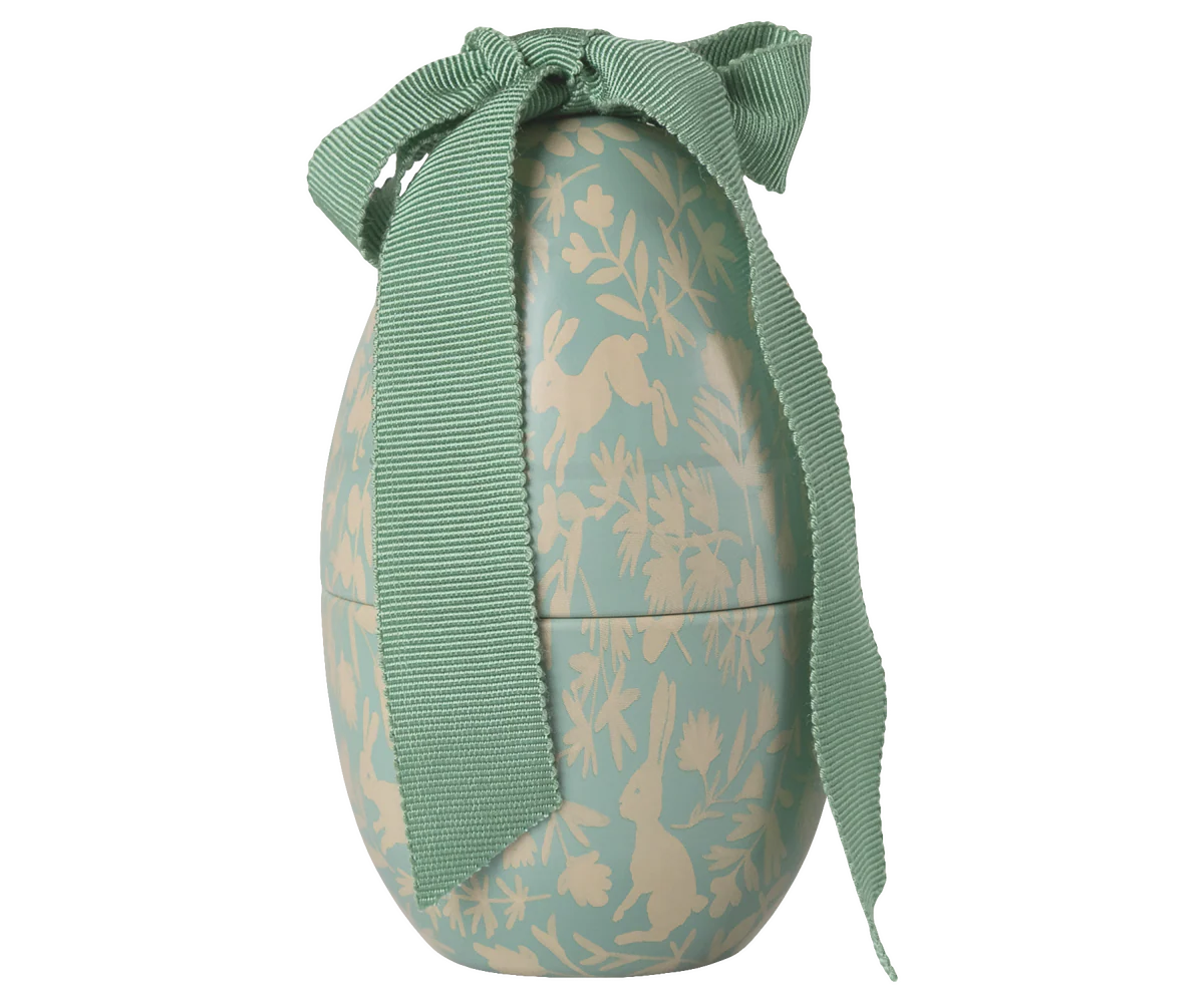 Decorative Easter egg with rabbit pattern and green ribbon on a white background