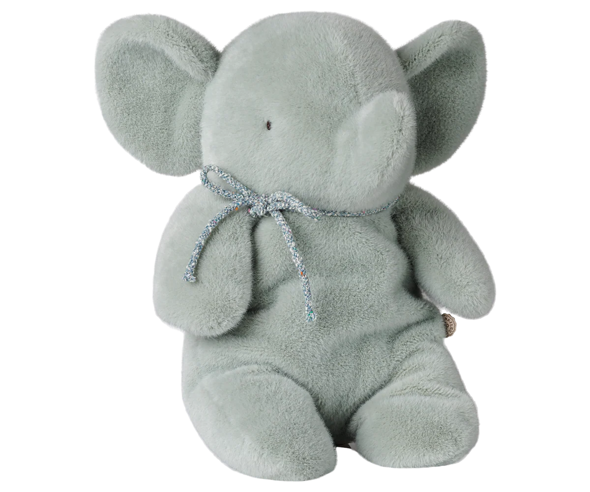 A light gray plush elephant toy with a glittery silver bow around its neck, set against a plain white background.