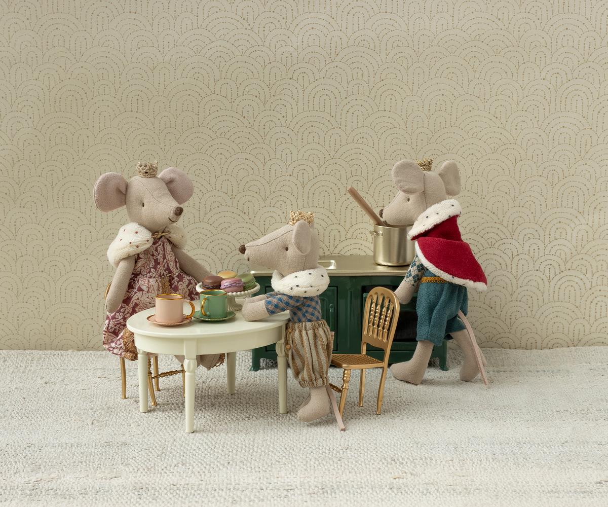 Miniature mouse figures in a tea party scene with a decorative background