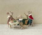 Miniature mouse figures in a tea party scene with a decorative background