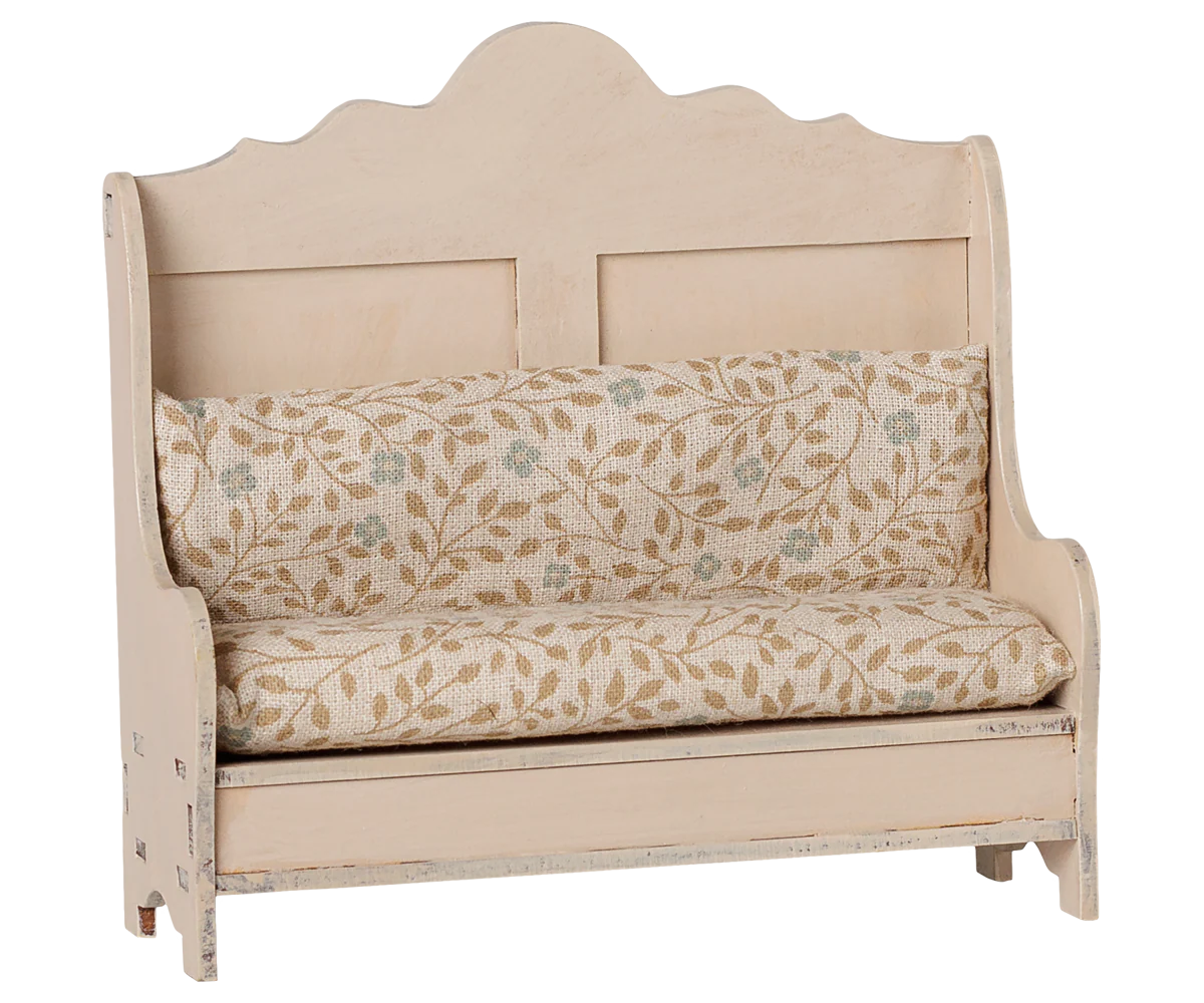 A rustic-style wooden bench with a distressed cream finish and a floral-patterned cushion set, shown against a plain white background.