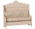 A rustic-style wooden bench with a distressed cream finish and a floral-patterned cushion set, shown against a plain white background.