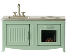 Mint green toy kitchen with sink and stove on a white background
