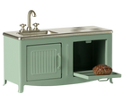 Green toy kitchen set with sink and stove on a white background