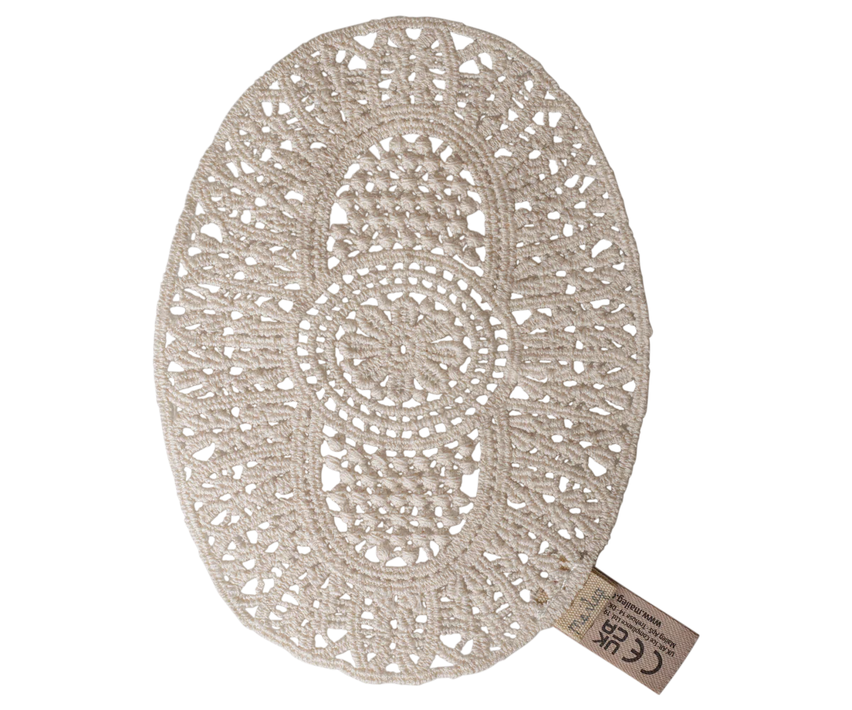 An oval cream-colored crocheted placemat with an intricate lace-like openwork pattern, shown on a plain white background with a small paper tag attached.