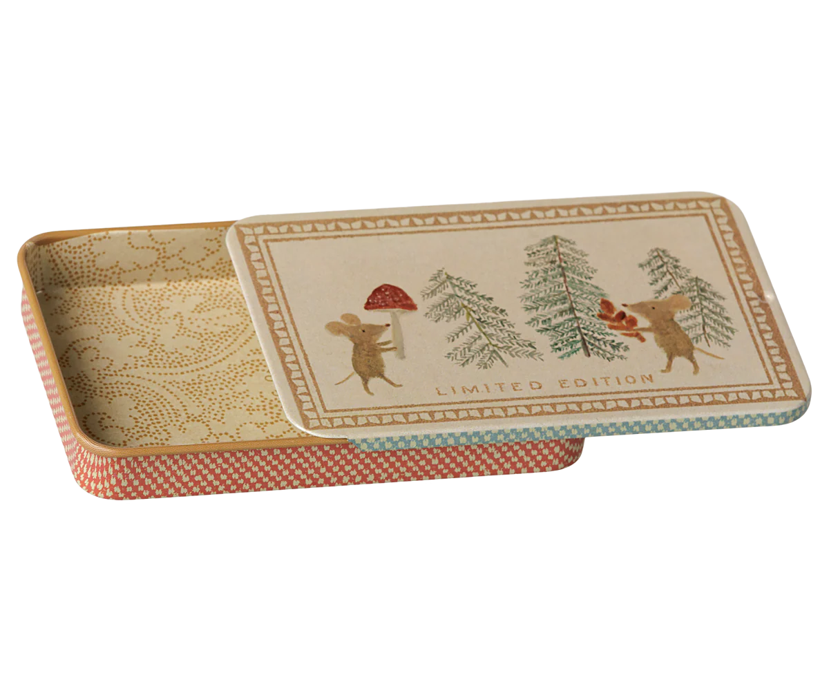 A rectangular decorative tin with its lid propped open, featuring a vintage-style illustration of two mice among pine trees on the lid, with the words 'LIMITED EDITION' printed near the bottom. The interior has a beige damask pattern, and the outer edge of the tin has a muted coral-red and cream checkered pattern.