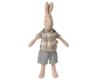 Stuffed rabbit toy wearing a plaid shirt and shorts on a white background