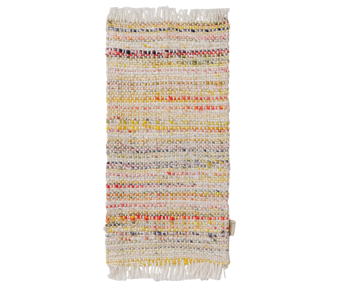 A rectangular woven rug with fringed edges, featuring horizontal stripes of cream, yellow, orange, red, and blue yarn on a white background.