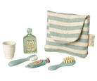 Set of children's dental care items including a cup, toothbrush, and toothpaste with a striped pouch on a white background.