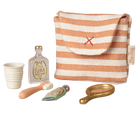 Set of miniature items including a striped bag, bottle, cup, and tools on a white background