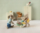 Maileg toy mice in a miniature room with a washing machine and chair.