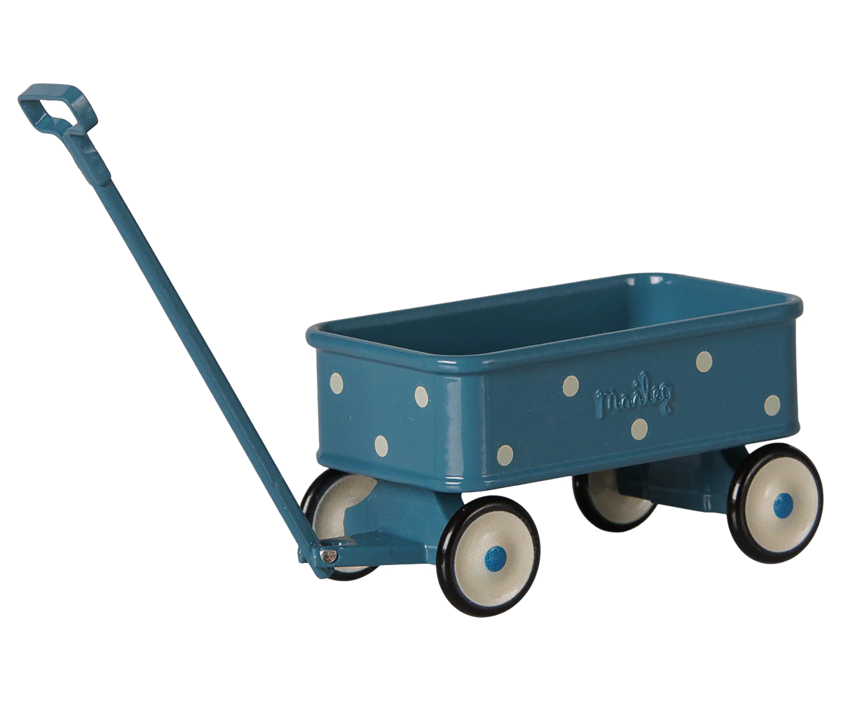 A teal blue toy wagon with white polka dots, cream-colored wheels with black rims, and a matching blue handle, shown on a plain white background.