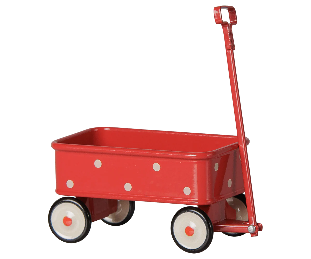 A classic red metal toy wagon with white polka dots, cream-colored wheels with black trim, and a red D-handle, shown against a plain white background.