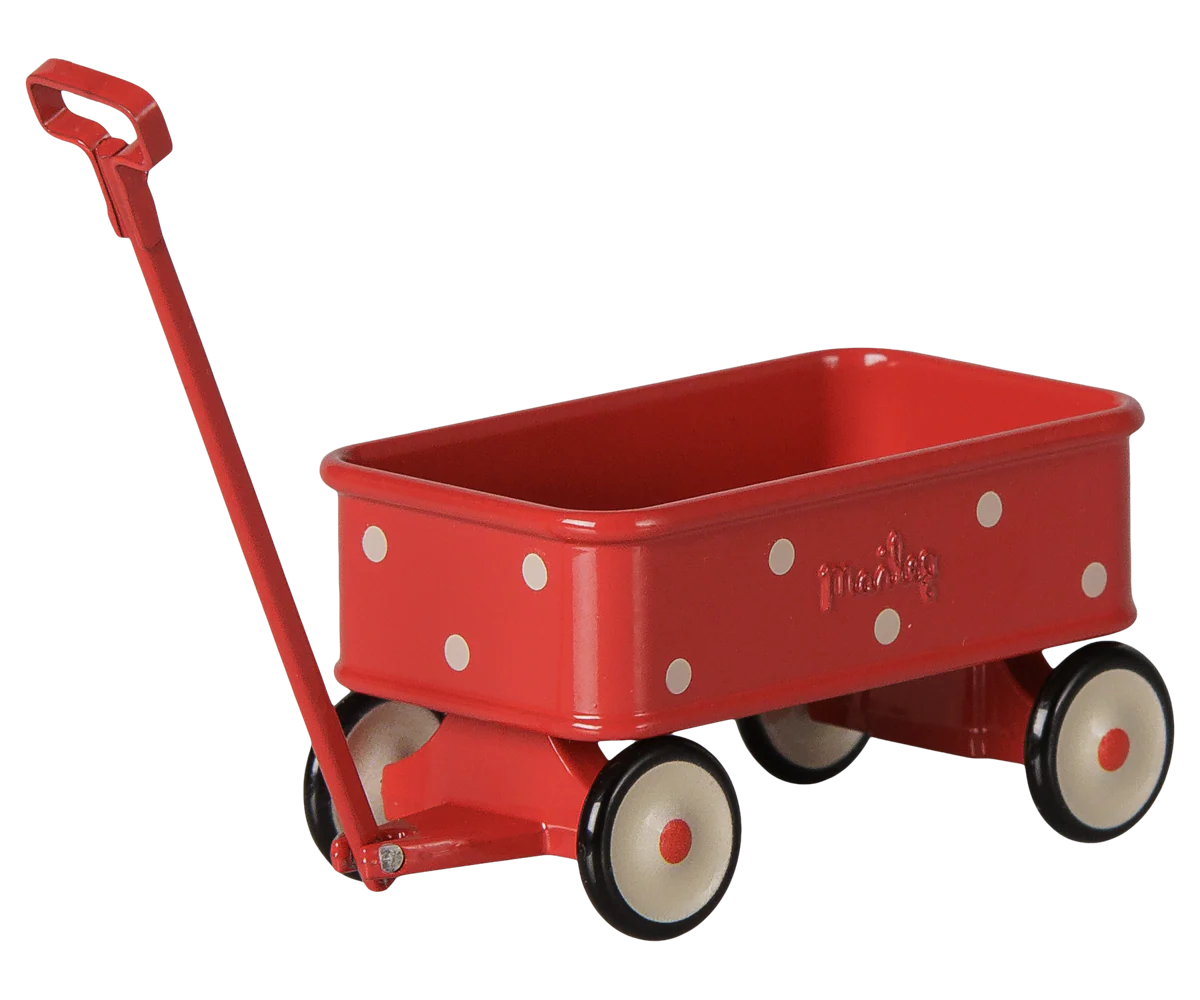 A red metal toy wagon with white polka dots, cream-colored wheels with black rims, and a red handle, shown on a plain white background.