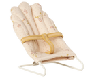 miniature dolls house baby bouncer with floral pattern and yellow strap on a white background