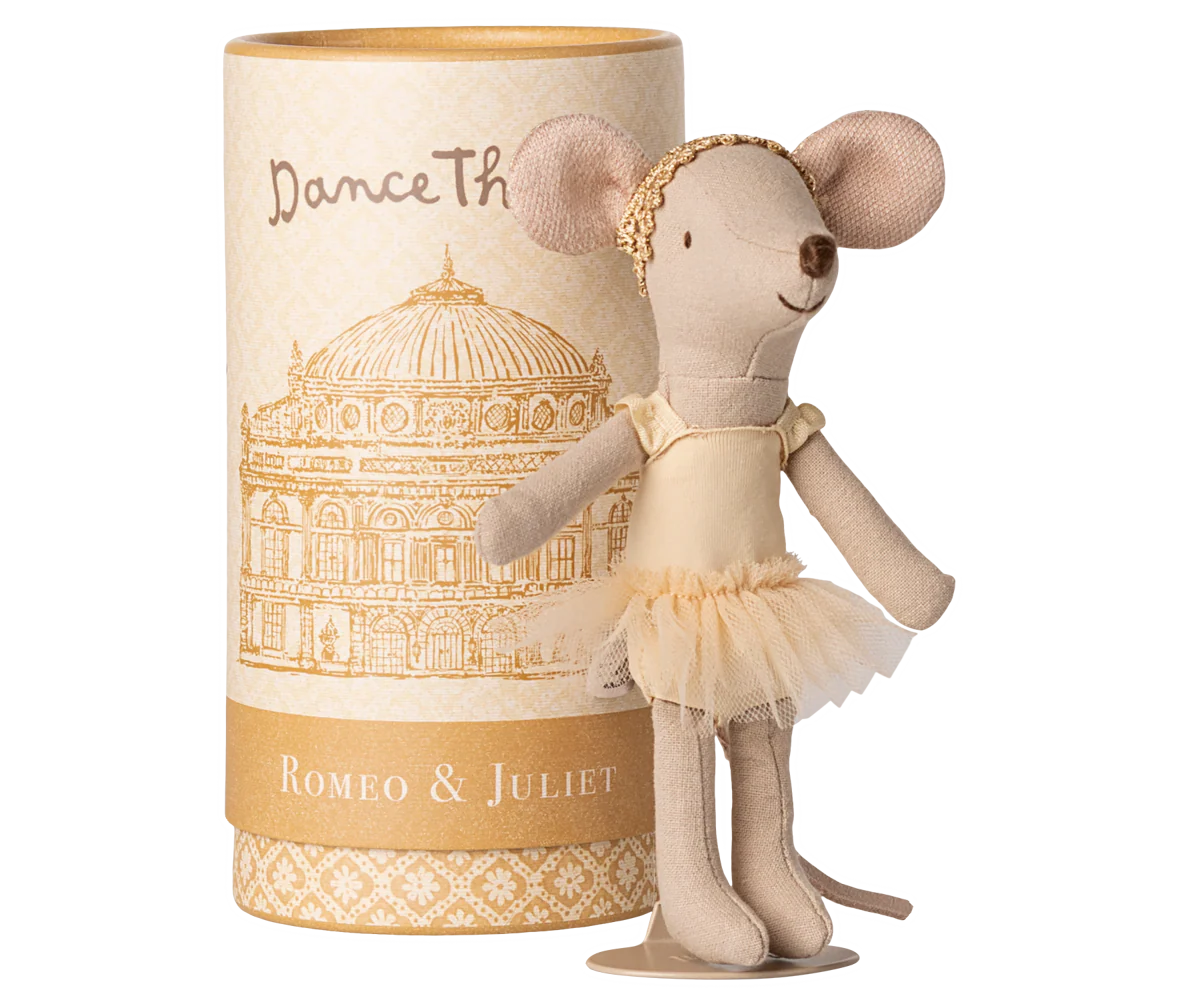 Stuffed mouse doll in a tutu dress next to a cylindrical box with decorative design and text.