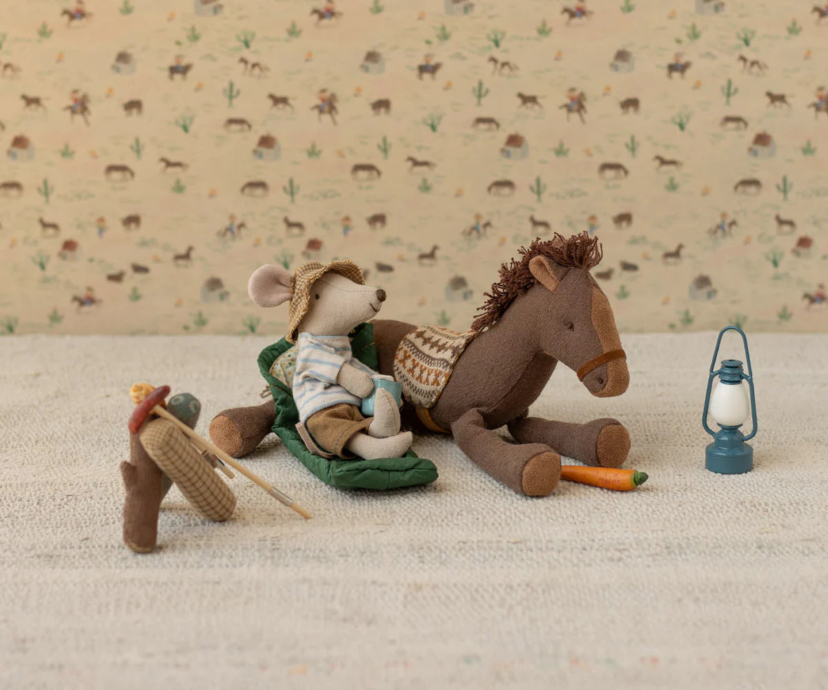 Stuffed mouse and horse with a lantern on a textured surface with animal patterned background
