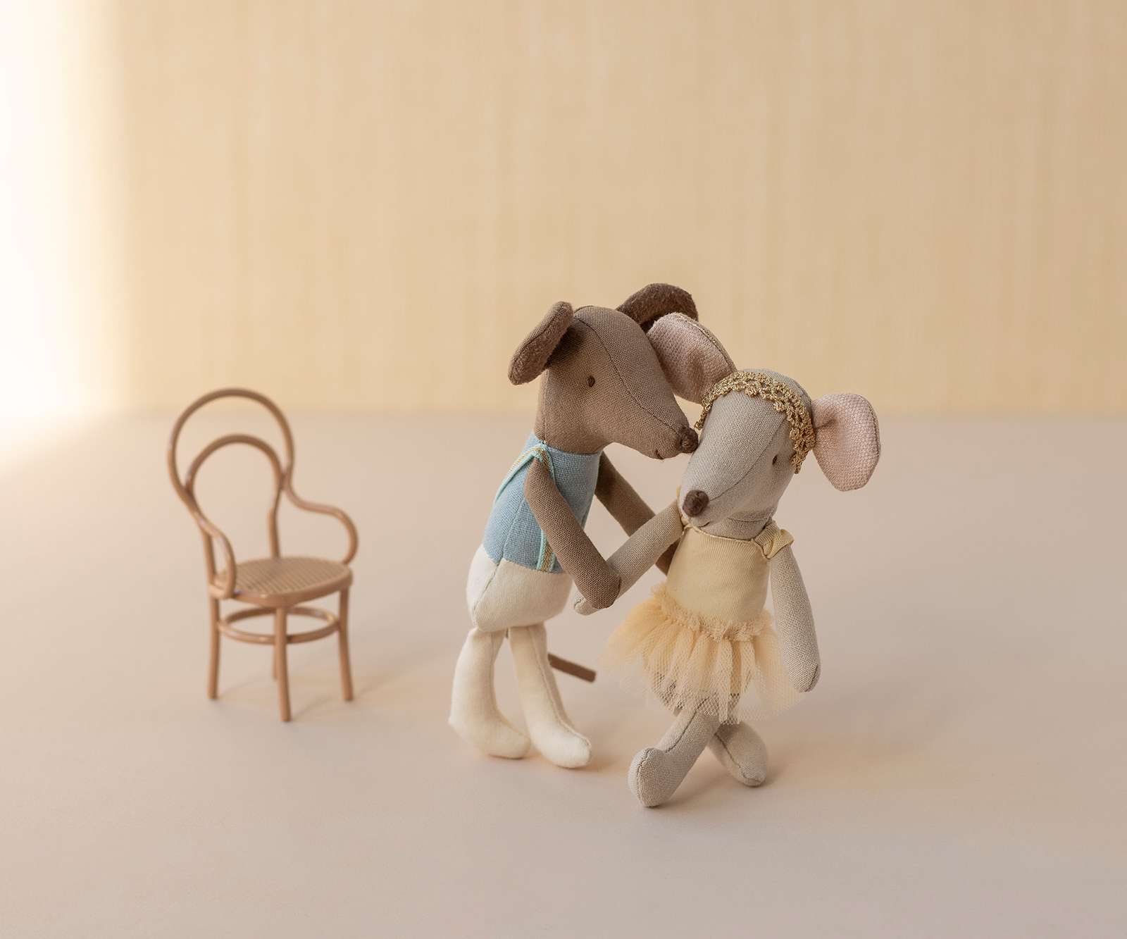 Two Maileg ballerina mice and a chair on a neutral background